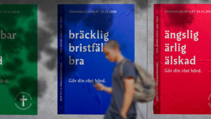 En man går längs en vägg där det syns reklam för församlingsvalet.